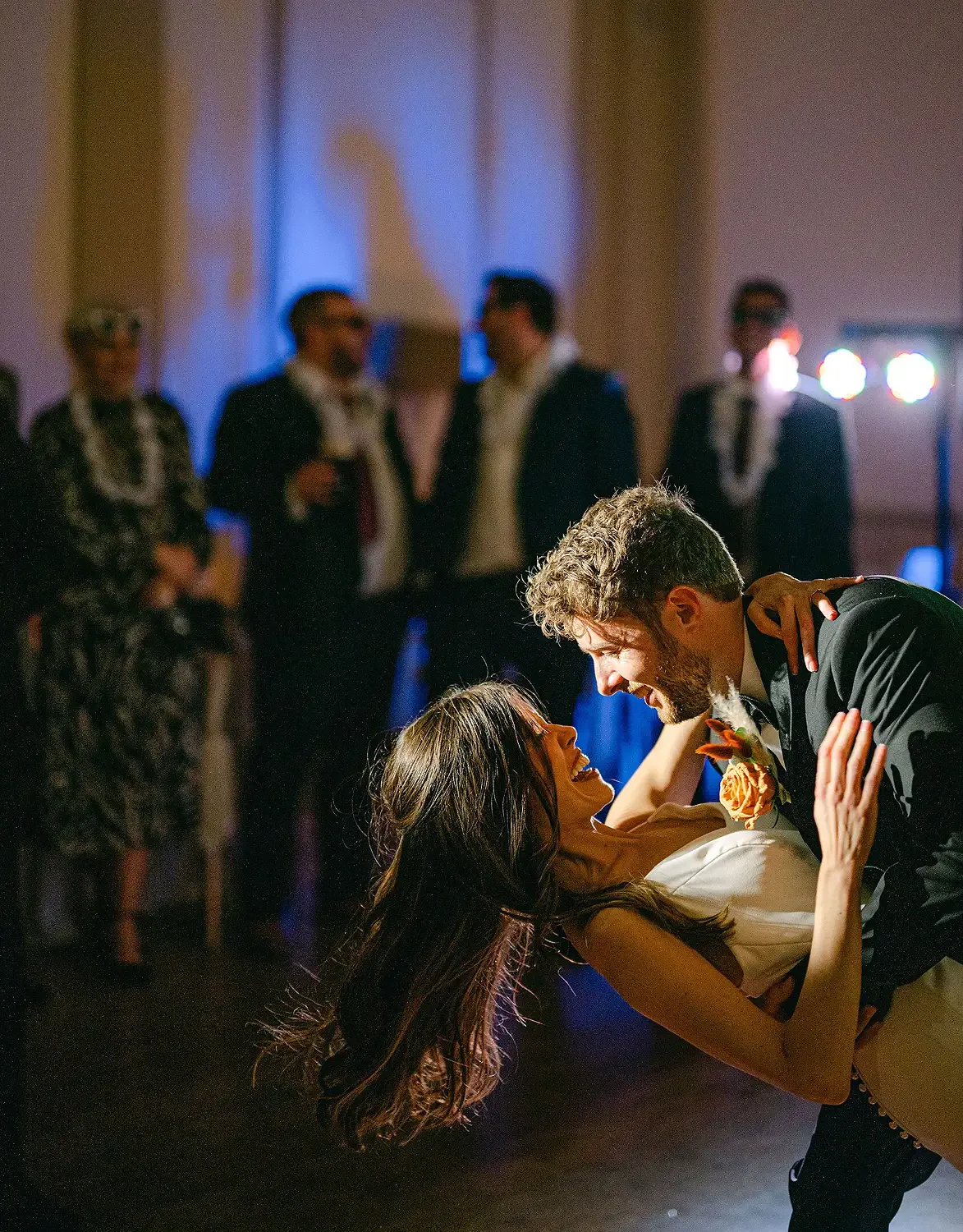 A couple dancing closely at a wedding reception, with friends in the background. Taken at Hodsock Priory