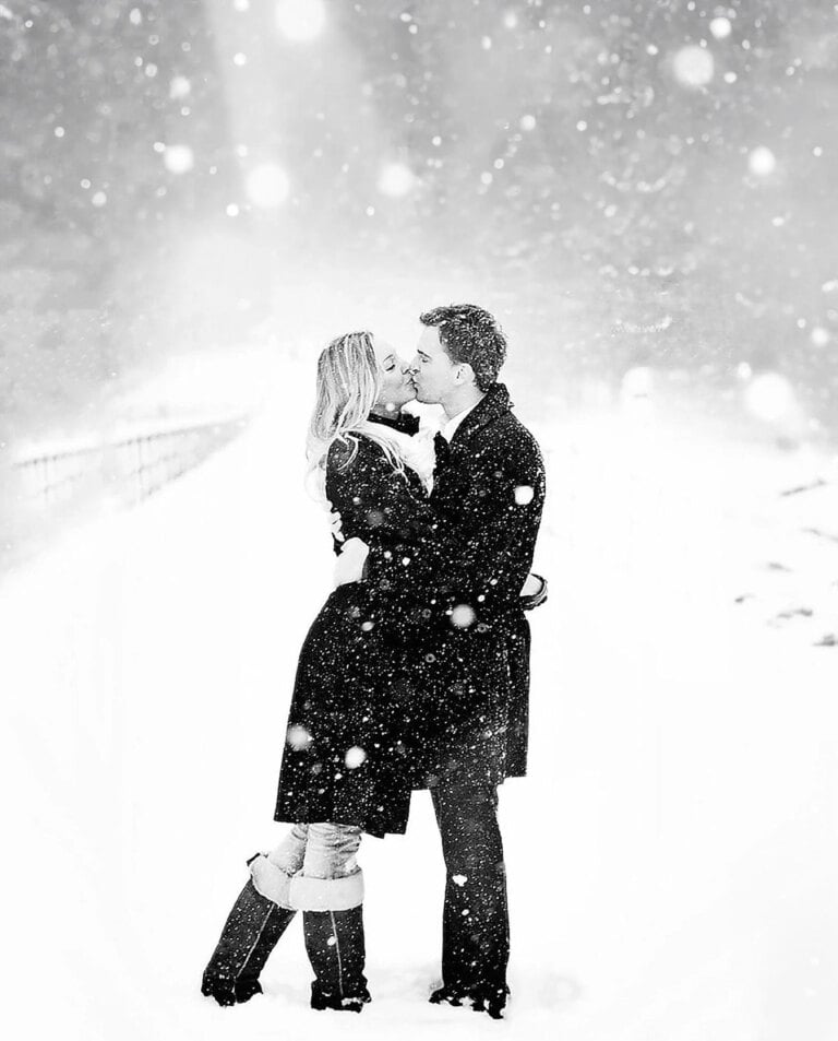 snowy day romatic black and white photo of a couple kissingin a snow fall. taken by a yorkshire wedding photograpaher