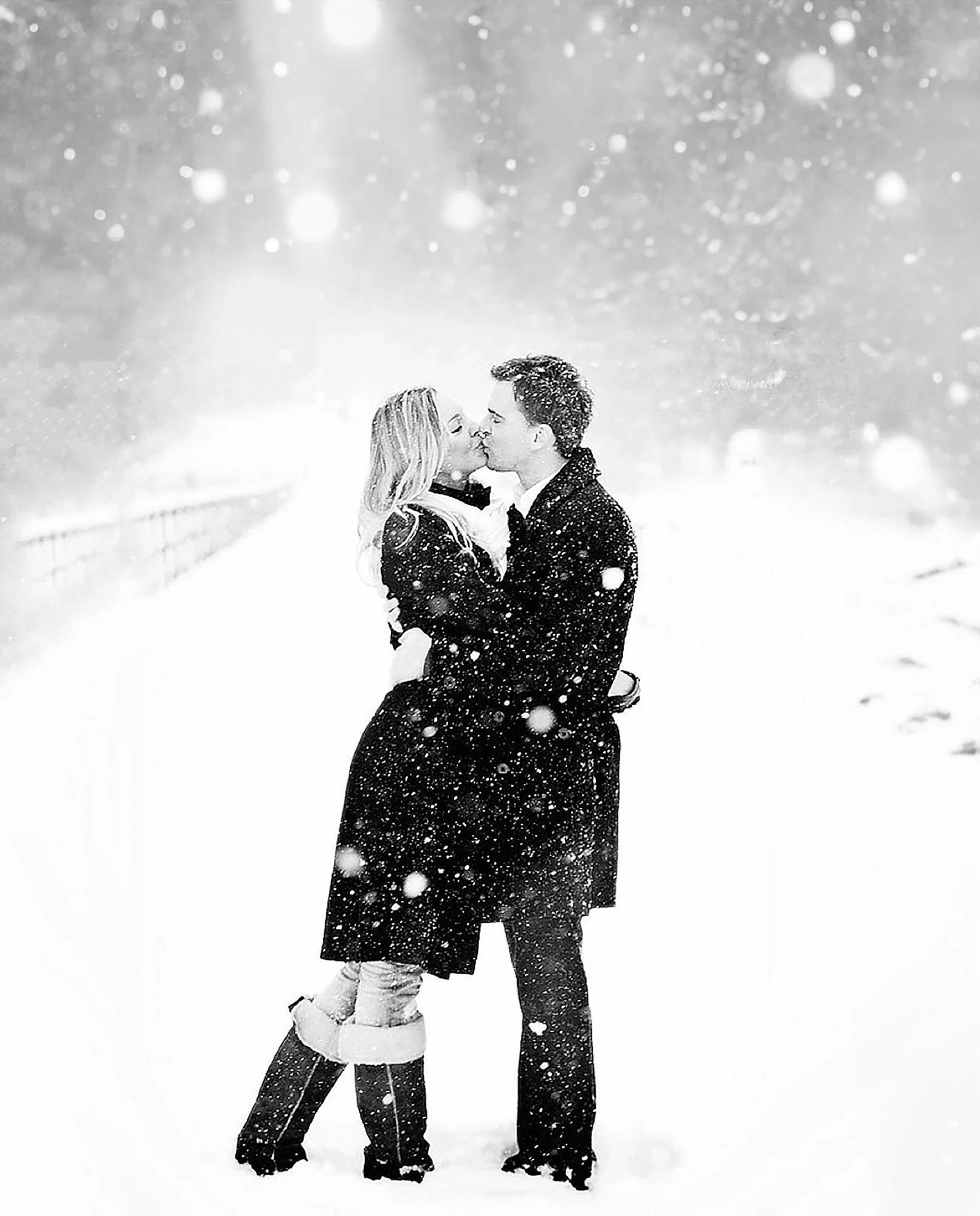snowy day romatic black and white photo of a couple kissingin a snow fall. taken by a yorkshire wedding photograpaher