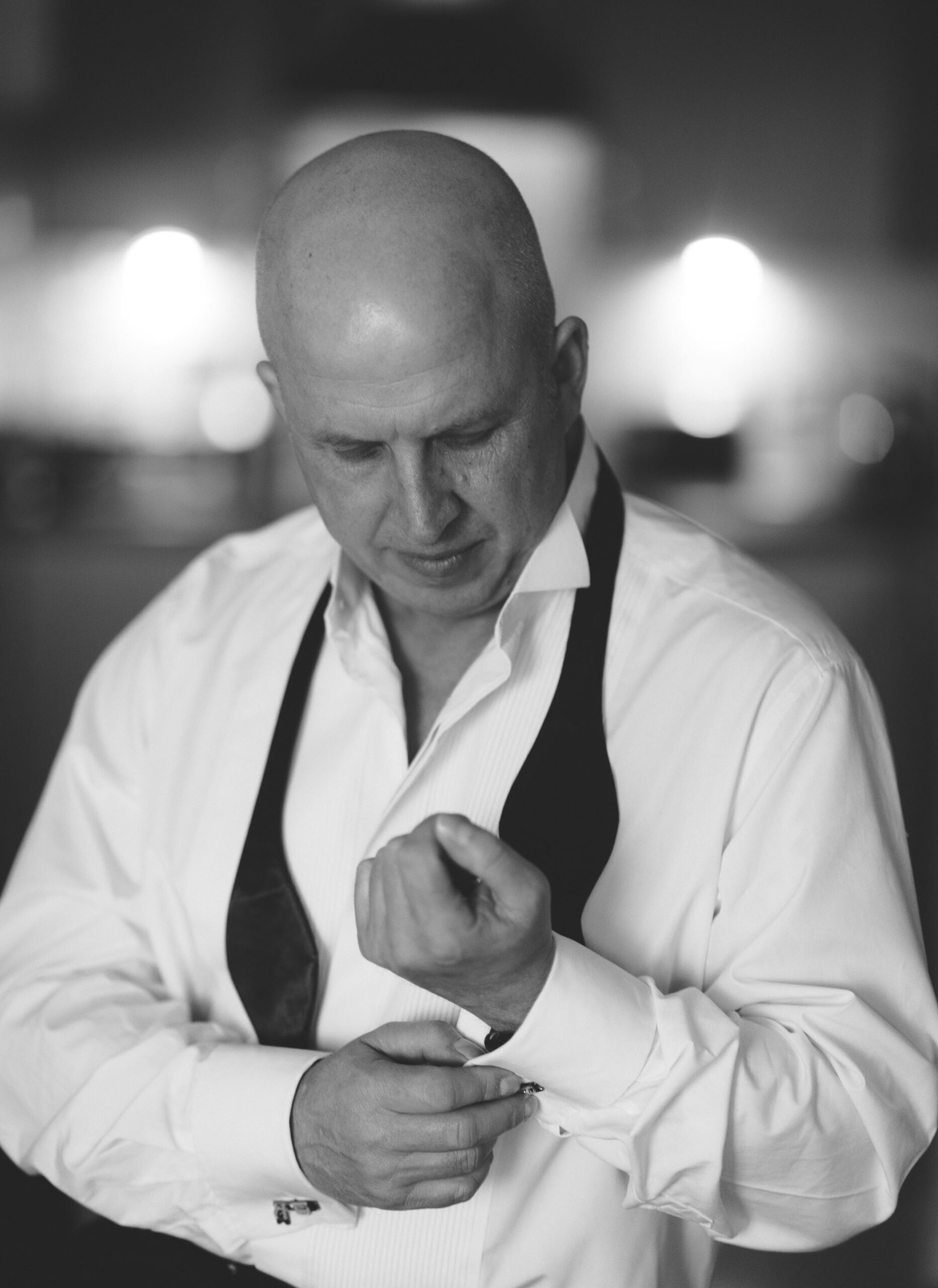 black and white hoto of bald man adjusting his cuff links - yorkshire commercial headshot photographer