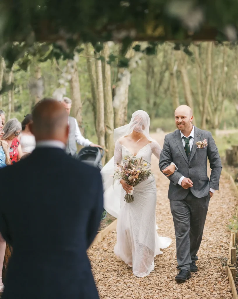 bride walking down woodland aisle with brother at Low Osgoodby Grange Wedding Photographer
