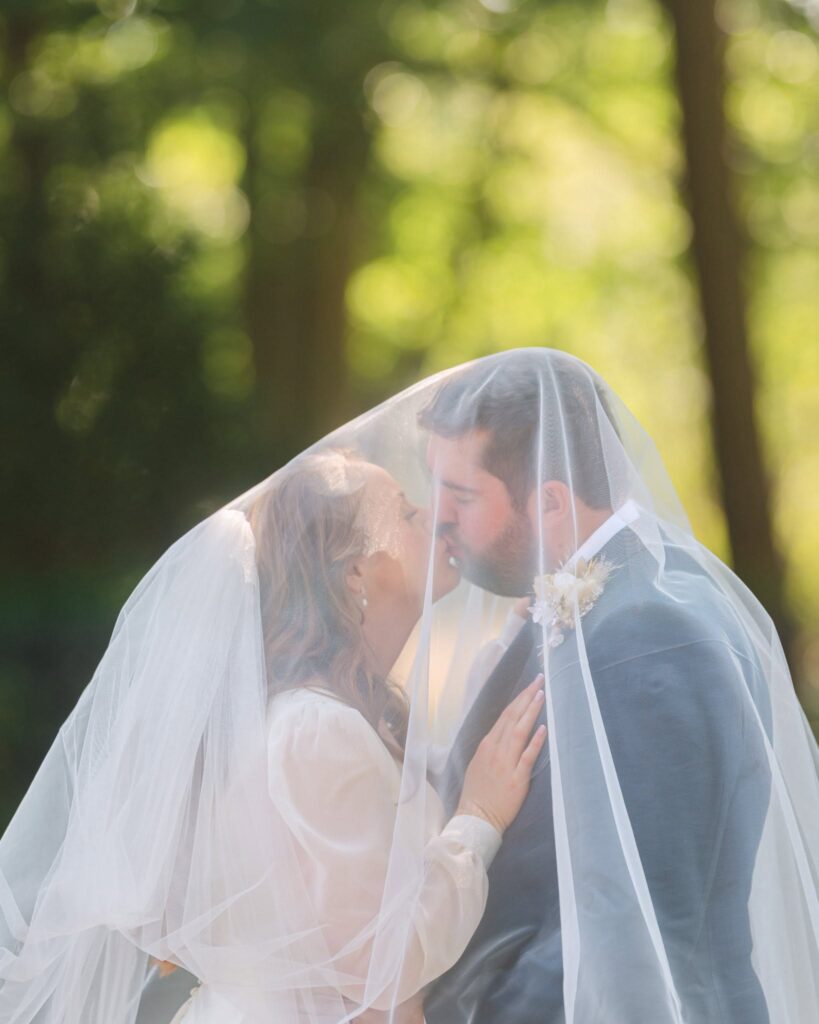 cockcliffe country house wedding photographer bride and groom kising under veil