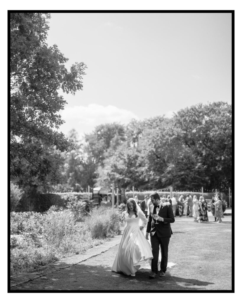 cockcliffe country house wedding photographer photo of bride and groom strolling in the gardens